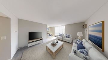 Birmingham townhouse for rent - A living room with a white couch, a coffee table, and a painting of a sunset.