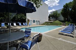 Ann Arbor apartment for rent - A pool area with blue chairs and a table.