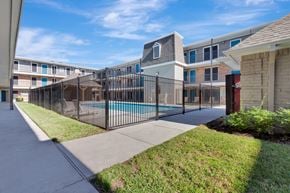 Houston apartment for rent - A black fence surrounds a pool in a residential area.