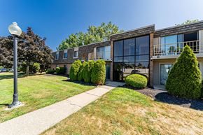 Willoughby apartment for rent - A modern building with a glass facade and a landscaped front yard.