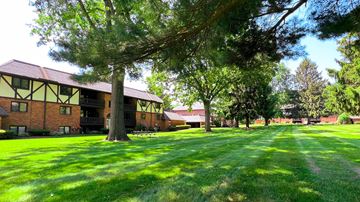 Canton apartment for rent - a large yard in front of a brick building with trees