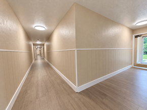 Willoughby apartment for rent - A long hallway with wooden floors and white walls.