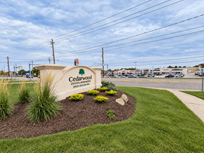 Willoughby apartment for rent - A sign for Cedarwood Estates is surrounded by a flower bed.
