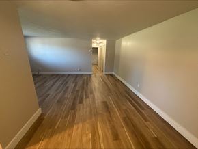 Middleburg Heights apartment for rent - A long hallway with wood flooring and white walls.