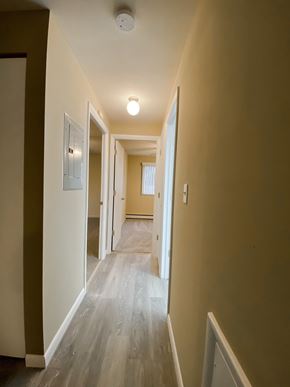 Brookpark apartment for rent - a view of a hallway with plank floors and a door to a bedroom