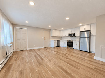 Brookpark apartment for rent - A kitchen with white cabinets and a wooden floor.