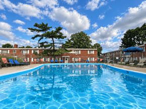 Brookpark apartment for rent - A large blue swimming pool in front of a building with red brick walls.