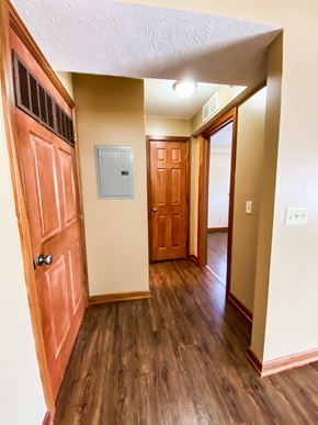 Mentor apartment for rent - an empty hallway with a wooden door and a door to a bedroom and a hallway at Hallwood Manor Apartments, Mentor, OH