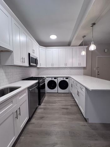 A white kitchen with white cabinets and stainless steel appliances