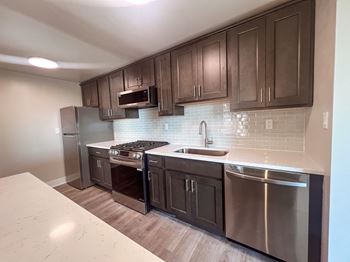A kitchen with stainless steel appliances and wooden cabinets