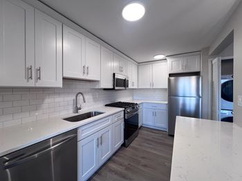 A kitchen with white cabinets and stainless steel appliances