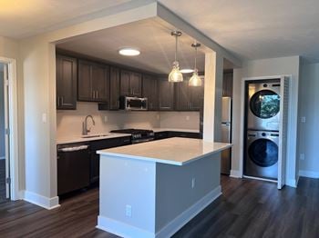 A kitchen with an island and a washer and dryer