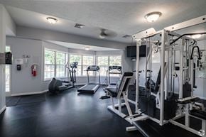Copley apartment for rent - A well-equipped gym with a variety of machines and a fire extinguisher on the wall.