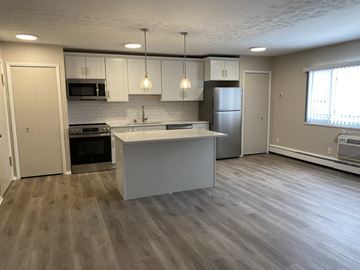 Willoughby apartment for rent - A kitchen with a white island and wooden floors.