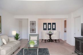 Parma apartment for rent - A living room with a sofa, a table with a vase of flowers, and a television at Hummingbird Pointe & The Gardens, Parma, 44129