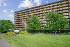 Parma Heights apartment for rent - A large apartment building with a lawn in front and a sign that says at Independence Place Apartments, Parma Heights, 44130
