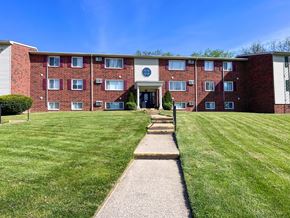 Ashland apartment for rent - a large brick apartment building with a lawn and sidewalk
