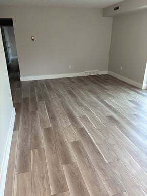 Willoughby apartment for rent - A room with a wood floor and a white wall.