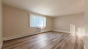 Parma Heights apartment for rent - A room with wooden flooring and a window with blinds.