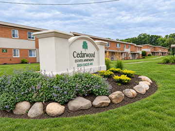 Willoughby apartment for rent - A sign for Cedarwood Estates Apartments sits in front of a building.