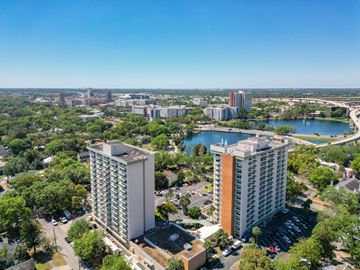 Orlando apartment for rent - A cityscape with two prominent buildings in the foreground and a body of water in the background.