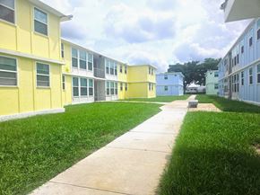 Ft Lauderdale apartment for rent - A long concrete walkway leads between two rows of identical buildings.