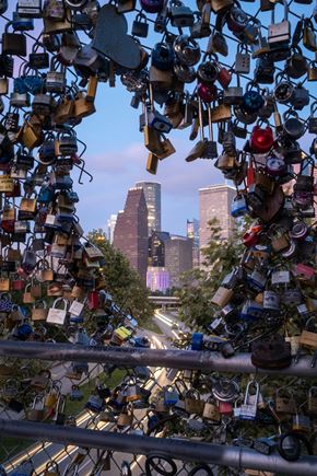 Houston apartment for rent - the city is seen through a bunch of locks on a fence