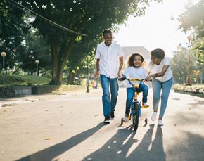 Houston apartment for rent - a young girl riding a bike down the street with her family