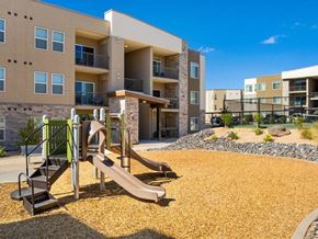 Washington apartment for rent - A playground with a slide and a climbing frame in front of apartment buildings.