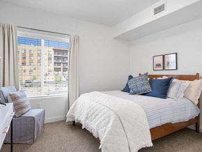 Washington apartment for rent - A bedroom with a large bed and a window overlooking a cityscape.