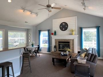 Sandy apartment for rent - A living room with a fireplace and a clock on the wall.