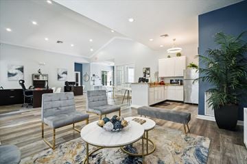 Clermont apartment for rent - A modern living room with a white coffee table and grey chairs.