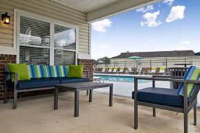 Springfield apartment for rent - A patio with a table and two chairs with a pool in the background.