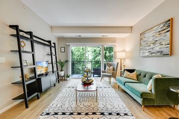 Rochester apartment for rent - a living room with a green couch and a sliding glass door
