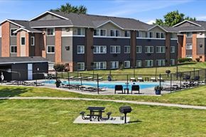 Ankeny apartment for rent - A large apartment complex with a pool and picnic tables.