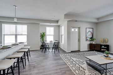 Woodbury apartment for rent - an open living room and dining room with chairs and tables and a bar