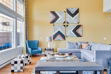 Rochester apartment for rent - a living room with yellow walls and blue furniture and a large window