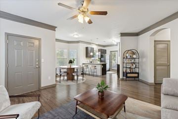 Pooler apartment for rent - A living room with a wooden coffee table and a ceiling fan.
