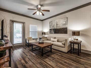 Tulsa apartment for rent - A living room with a couch, a chair, a coffee table, and a painting on the wall.