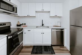 Cleveland apartment for rent - a kitchen with white cabinets and stainless steel appliances