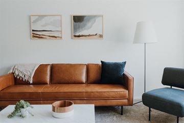 Willoughby apartment for rent - a living room with a brown couch and two paintings on the wall