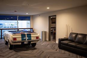Redlands apartment for rent - a pool table sits in the middle of a room with a couch and chair at The Crossings at Redlands, California, 92374