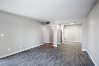 An empty living room with a hardwood floor