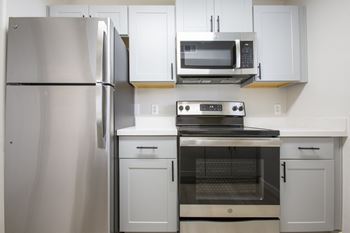 A kitchen with white cabinets and stainless steel appliances
