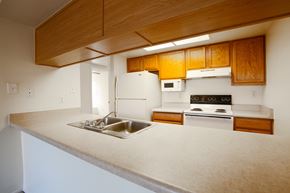 Tempe apartment for rent - A kitchen with wooden cabinets and white appliances.at Ascent on Spence, Arizona