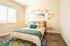 Queen Creek apartment for rent - Model bedroom is furnished with a large bed and 2 nightstands at Village Greens of Queen Creek