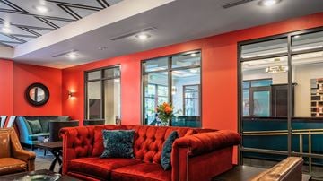 Troy apartment for rent - a living room with red furniture and large windows