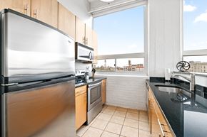 Philadelphia apartment for rent - a kitchen with black countertops and stainless steel appliances and a large window