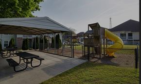Greenville apartment for rent - A playground with a yellow slide and picnic tables.