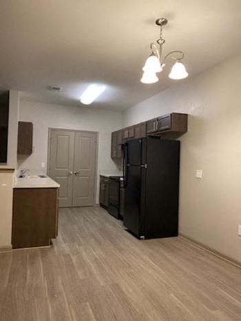Kitchen with black appliances and wooden cabinets.